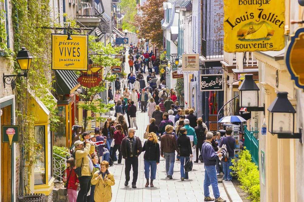 People walking about on a street lined with cafes and boutiques