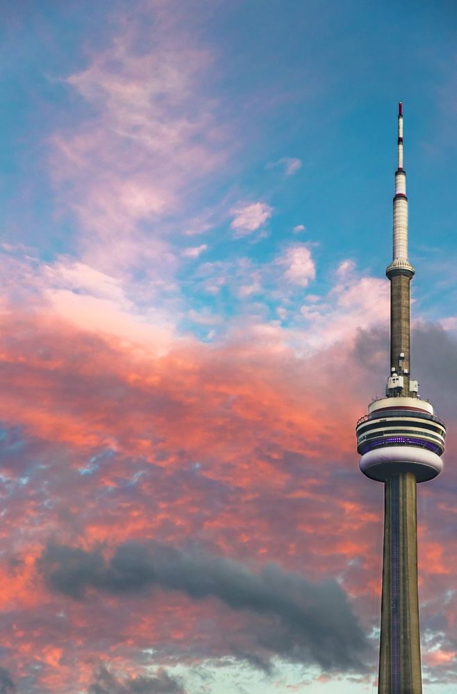 https://dev.canadianvisa.org/blog/cities-and-places/toronto/10-reasons-to-visit-toronto The sun setting on the CN Tower