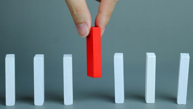 What's the Difference Between the FSWP & the FSTP? hand putting red domino in row of white dominoes | Differences Between FSWP and FSTP