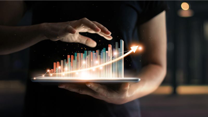 hands-holding-i-pad-with-increase-in-bar-graph | live and work in Canada