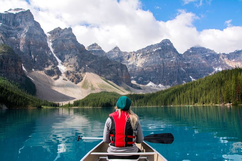 Work in Canada for Better Job Satisfaction woman in boat moraine lake alberta canada enjoying the quality of life | live and work in Canada